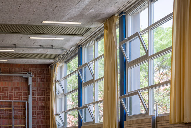 Praedinius 高级中学的 Slimchain 24V 开窗器 随时随地打开窗户呼吸新鲜空气。自动开窗器是最佳解决方案，可与电子控制系统共同通过二氧化碳、温度、消防或烟雾传感器或智能建筑控制系统 (KNX) 完全与楼宇管理系统连接。