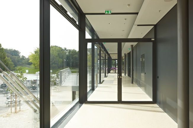 上置滑尺式闭门器 TS 5000 R-ISM, 安装在慕尼黑的顾拜旦广场。 采用 TS 5000 R-ISM 的防火分区门，用于双扇门的滑尺式闭门器系统，具有顺闭器和烟雾开关。