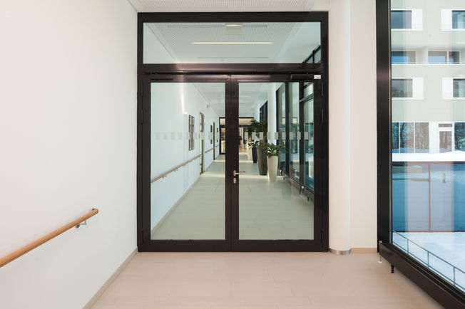 上置滑尺式闭门器 TS 5000 R-ISM, 安装在斯图加特的 Augustinum。 采用 TS 5000 R-ISM 的防火分区门，用于双扇门的滑尺式闭门器系统，具有顺闭器和烟雾开关。