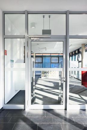 闭门器 TS 5000 R, 安装在波恩附近的 Alfter 艺术学院。 闭门器提供最佳的易通行性，以极简的设计完美地融入整体设计中。 TS 5000 R 由于具有烟雾开关，因此，也可以安装在防火隔烟门上。