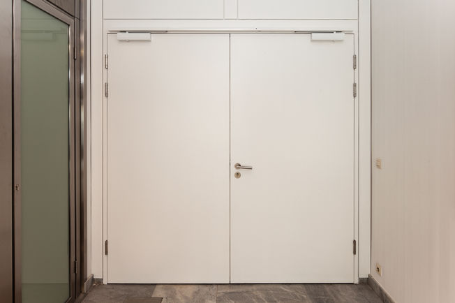 上置滑尺式闭门器 TS 5000 R-ISM TS 5000 R-ISM, 上置滑尺式闭门器系统，用于双扇门，具有顺闭器和烟雾开关，安装在位于 Leonberg 的 GEZE GmbH。