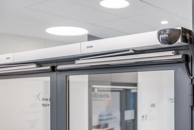 Swing door system Slimdrive EMD-F IS at Medicus Clinic in Wrocławiu, Poland Electromechanical swing door drive system for 2-leaf fire and smoke protection doors with closing sequence control, obstacle detection, automatic reversing and Push & Go function.