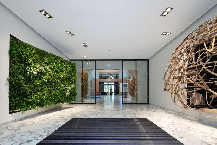 View into a modern passage of an office building with glass doors.