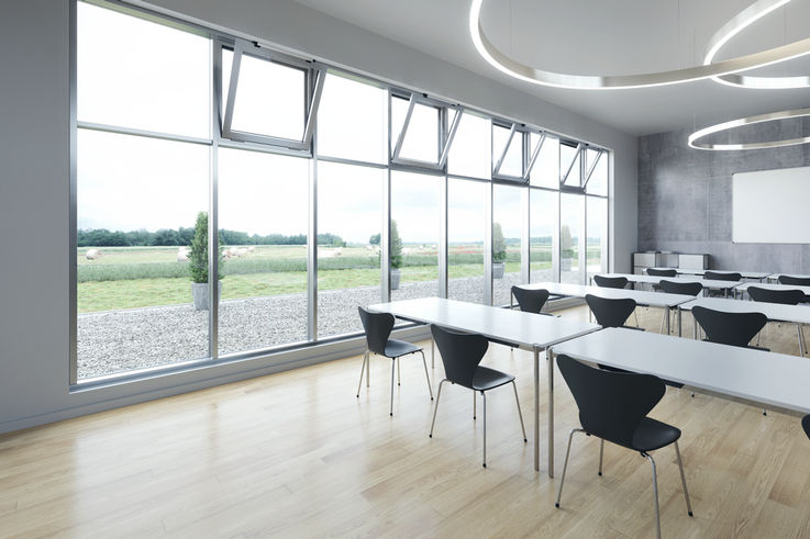 Classroom with a large window façade and automated windows. 