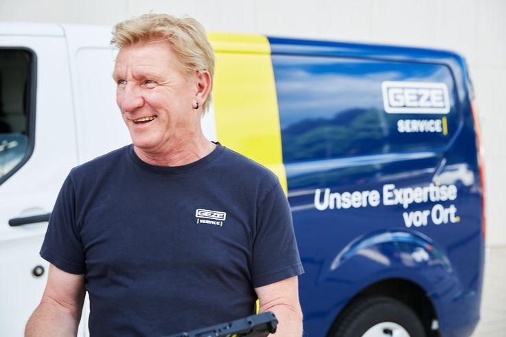 Portrait of service technician Michael Meyer in front of GEZE service vehicle