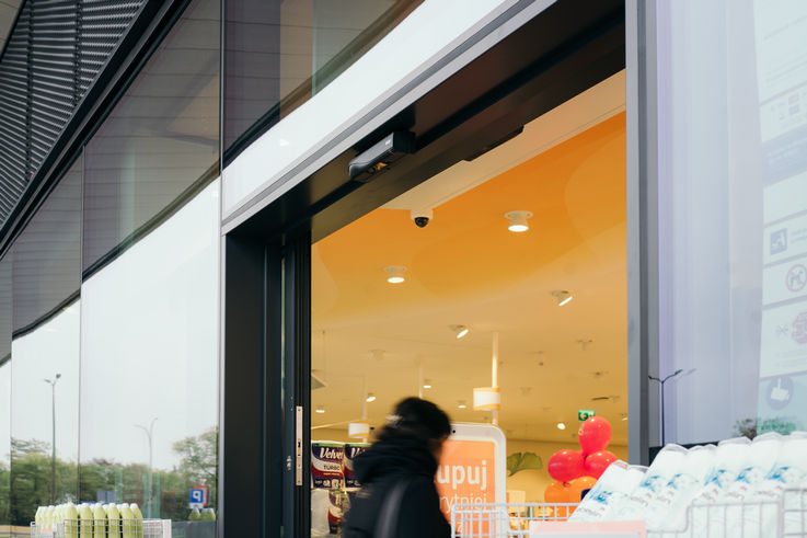 一名顾客正通过自动玻璃门进入 dm 连锁店。