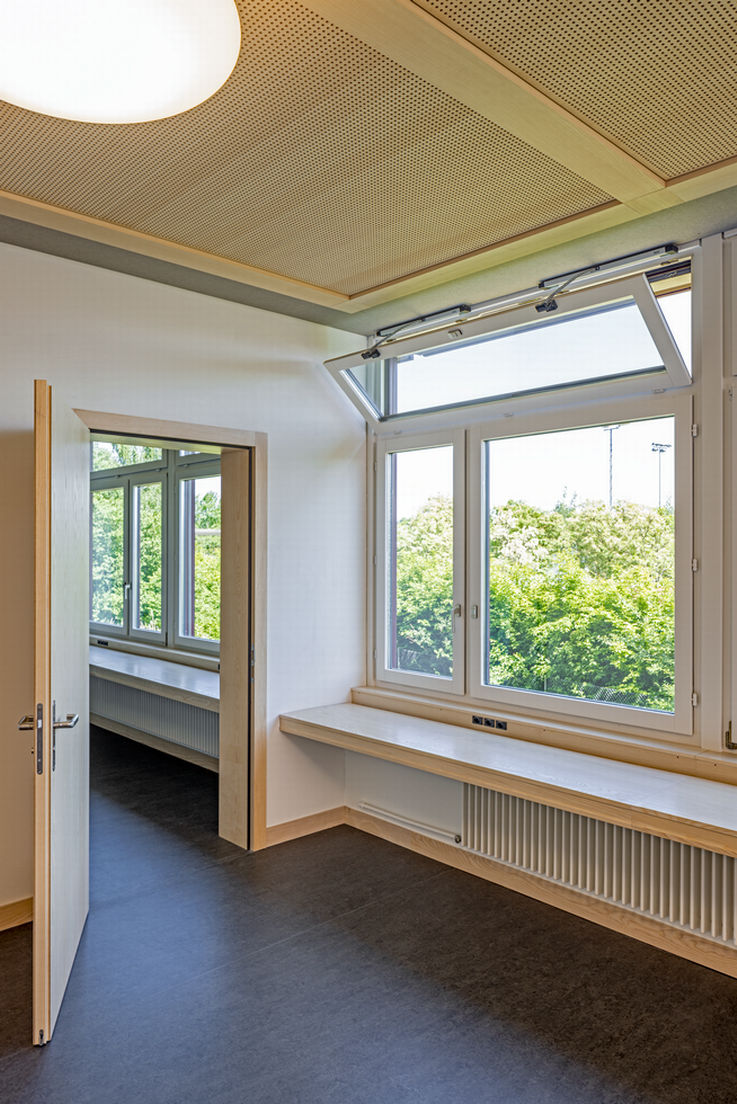 Classrooms with open passage doors and window fronts on the right