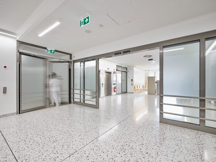 Bright hallway in a modern building with sliding doors and a lift 