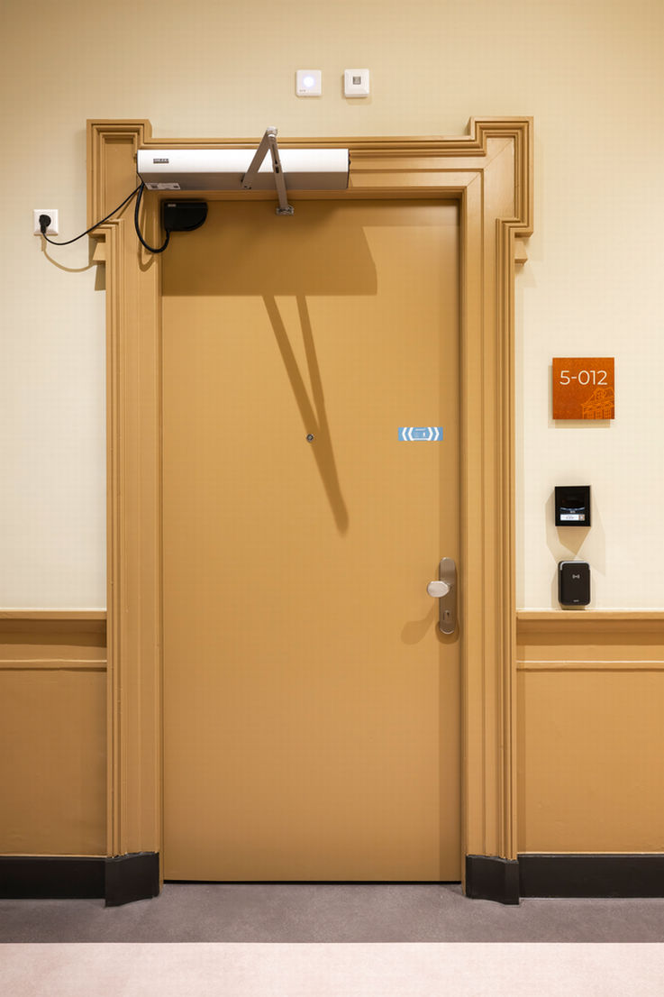 View of a closed room door fitted with a GEZE door closer