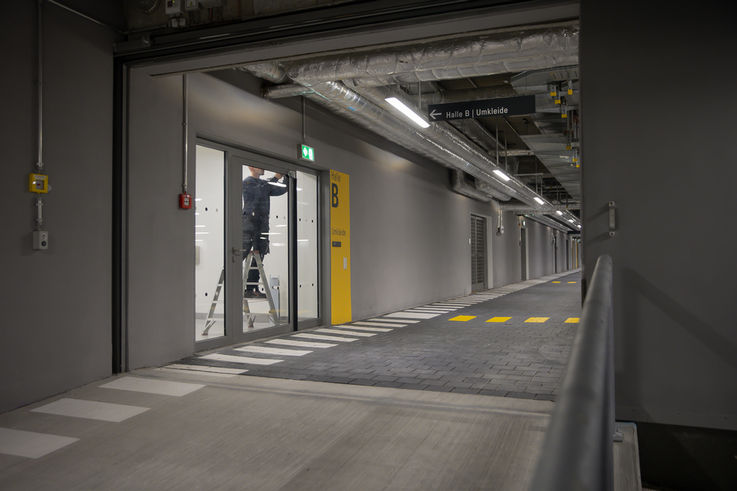 GEZE Service technicians installing a door closer on a large glass door