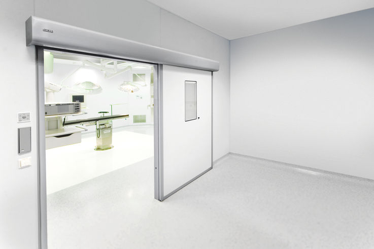 Automatic linear sliding door system for large heavy doors in areas with increased hygiene demands