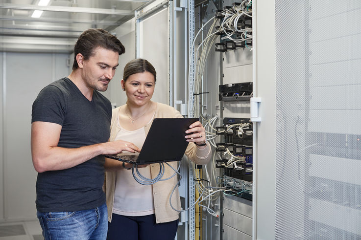 站在控制柜锁前查看笔记本电脑的 GEZE 员工